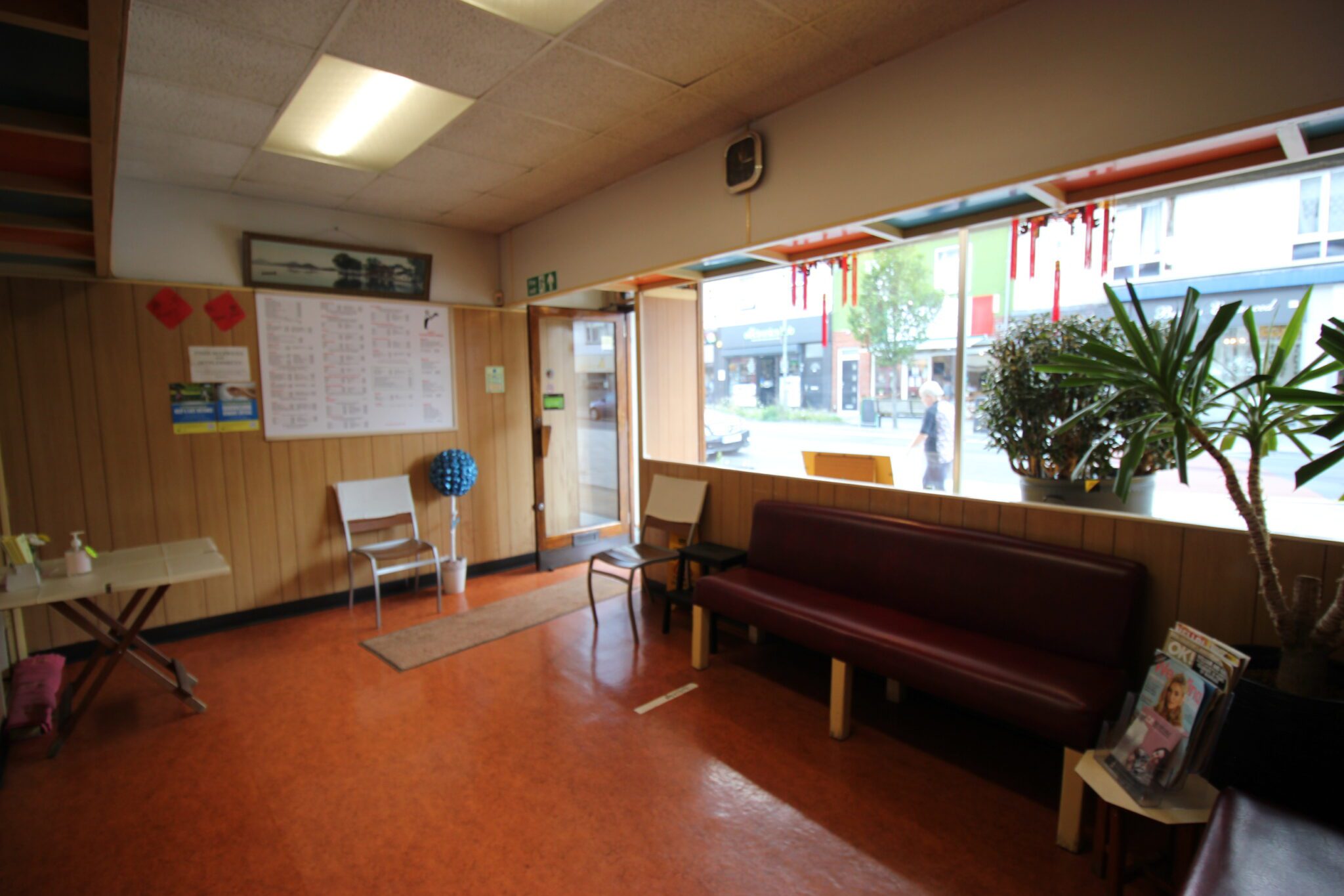 Interior of a takeaway reception counter - shop front, with money tree plant in window and seating