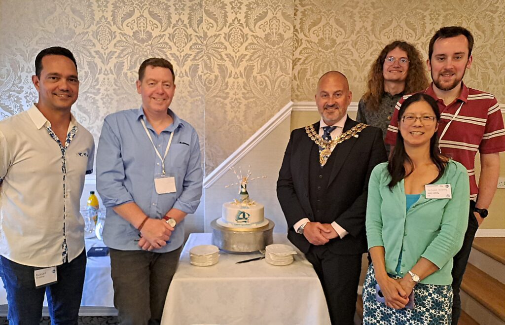 Members of Solent speakers with lord mayor in front of the cake, left to right, russell, george, mayor, alex, sau and barnaby.