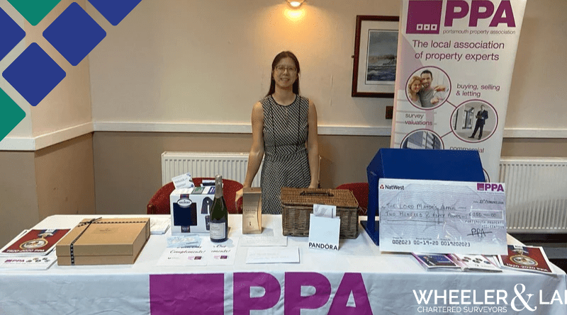 Sau behind the raffle table with PPA BANNER behind.