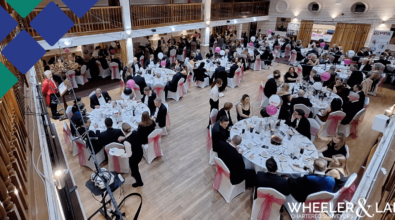 Aerial view of the hall with dinner guests at the table, decorations around.